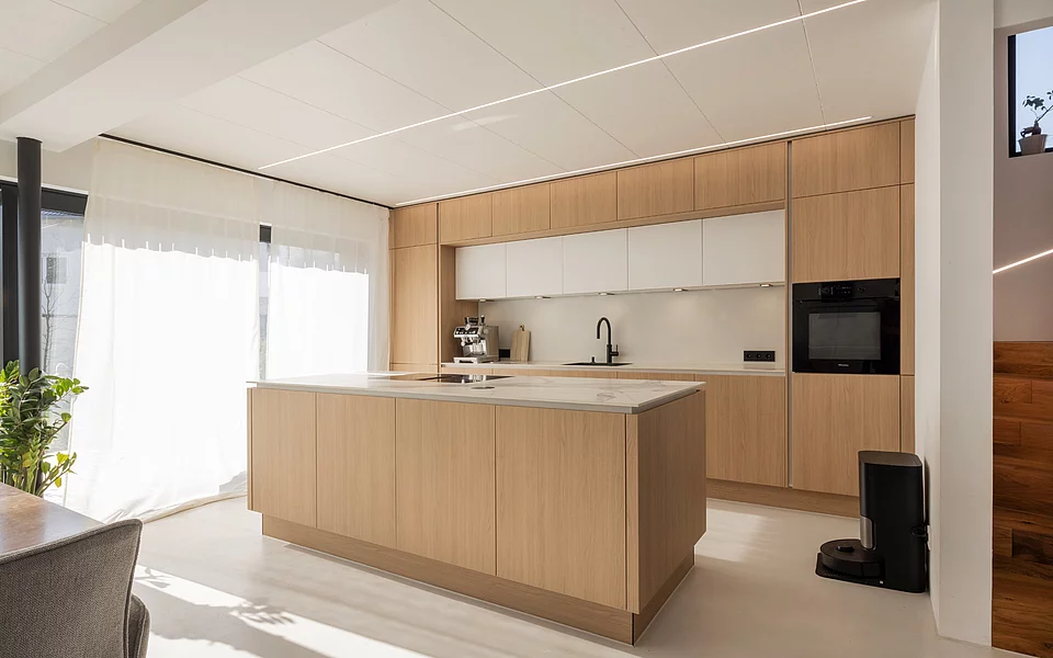 Moderne Küche mit zentraler Kochinsel, hellen Fronten und viel Stauraum, realisiert vom Küchenstudio Lorinser