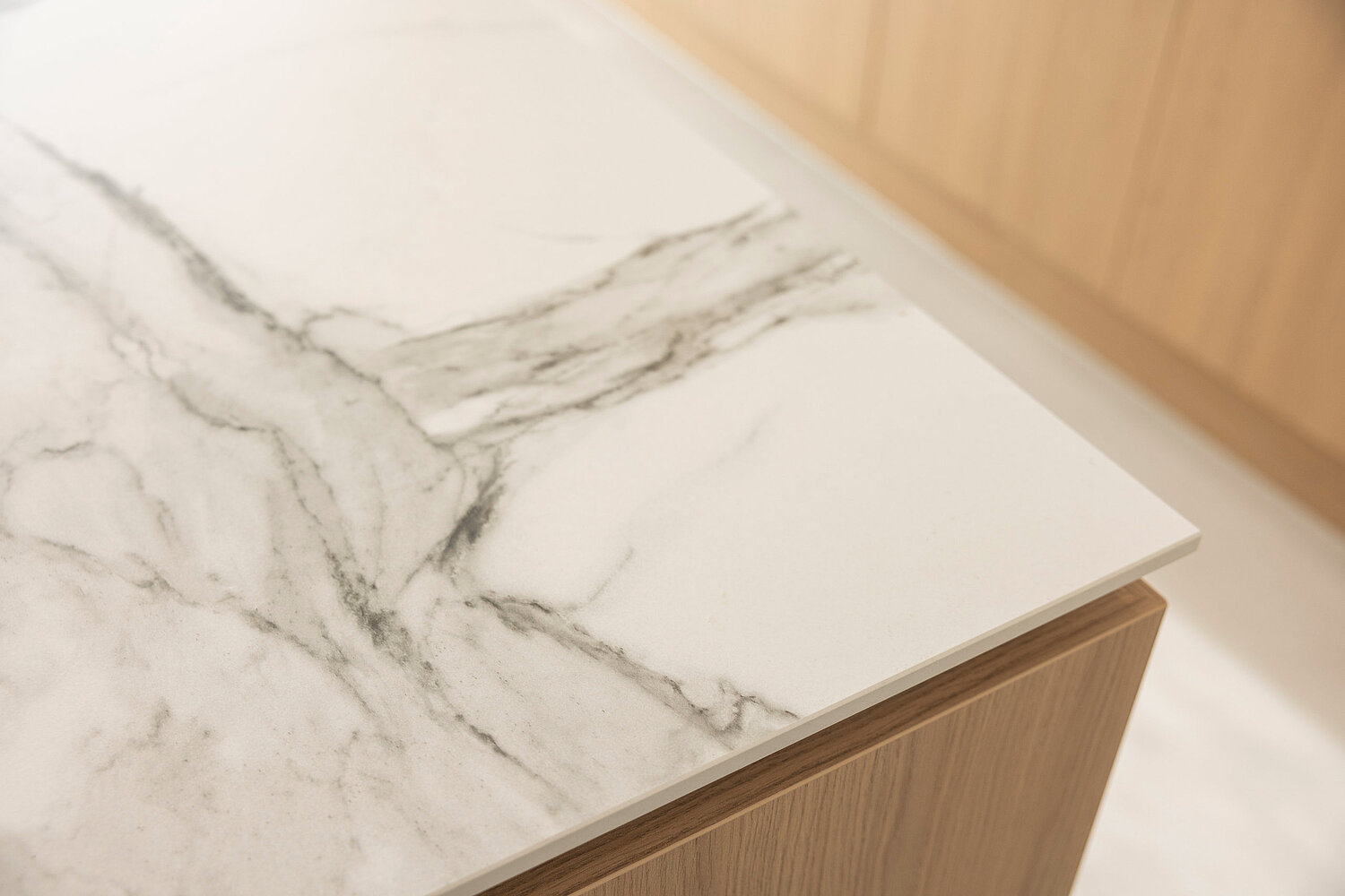 Schlichte Küchenzeile mit hellen Fronten und integriertem Kochfeld, geplant und umgesetzt von Küchenstudio Lorinser