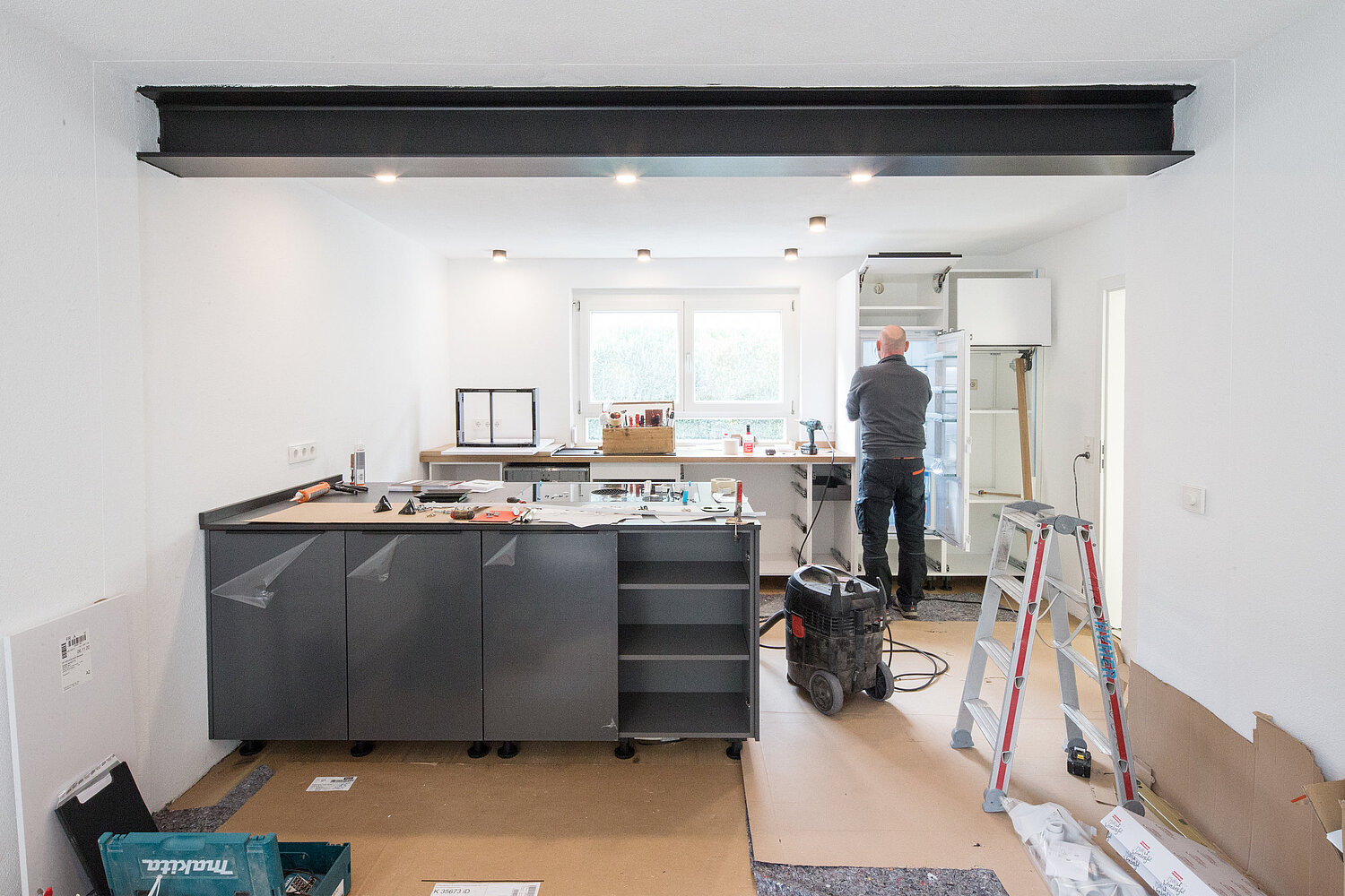 Offene Küche mit Kochinsel, dunklen Fronten und stilvollem Design, umgesetzt vom Küchenstudio Lorinser