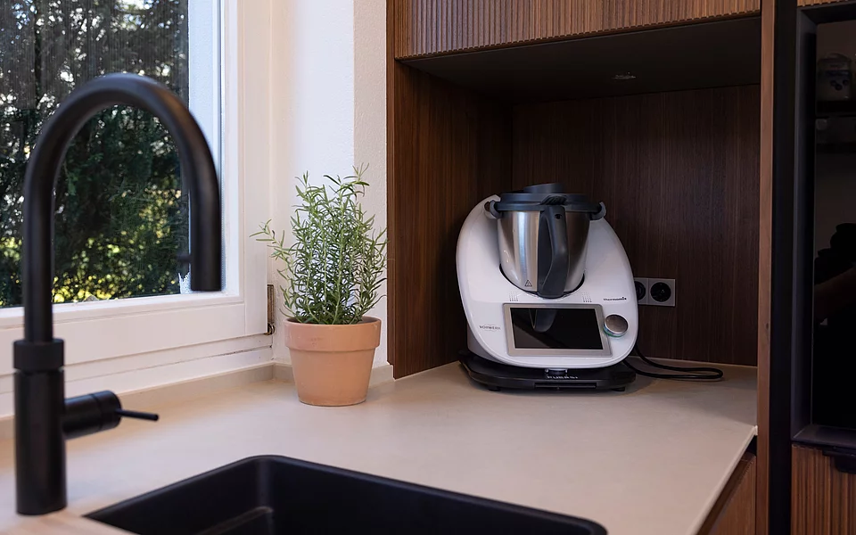 Offene Küche mit großen Fenstern und Blick ins Grüne, geplant und umgesetzt vom Küchenstudio Lorinser