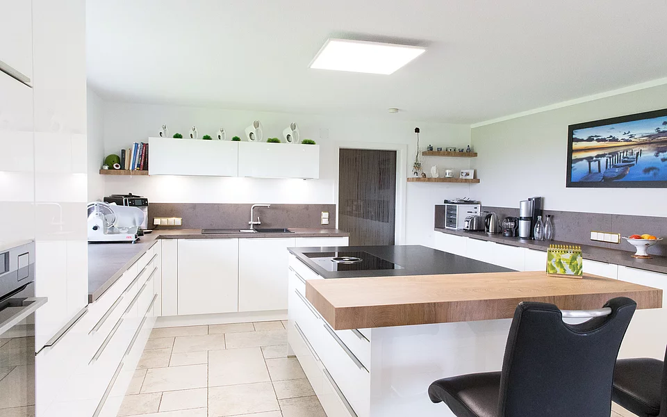 Moderne Wohnküche mit Esstisch, hellen Fronten und großzügigem Raumkonzept, realisiert vom Küchenstudio Lorinser