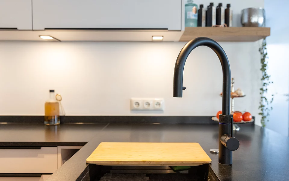 Helle Küche mit Spülbereich, modernen Armaturen und klarer Optik, geplant vom Küchenstudio Lorinser