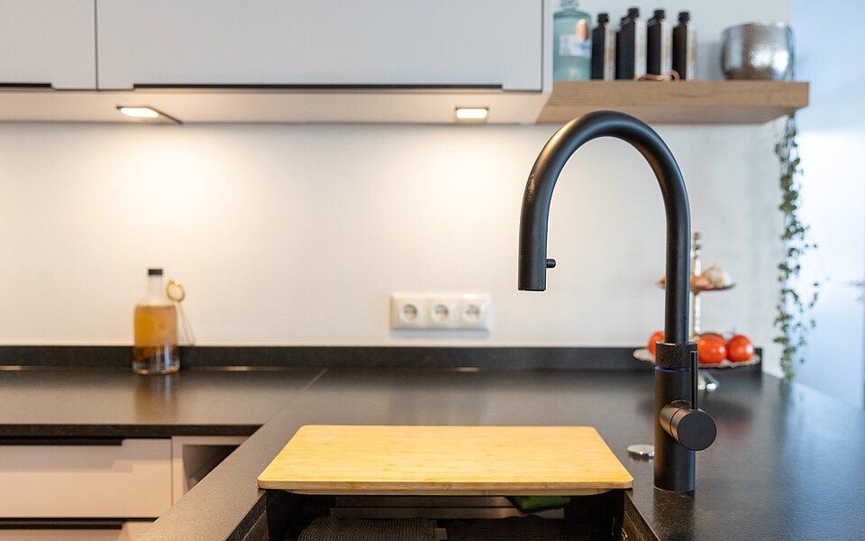 Helle Küche mit Spülbereich, modernen Armaturen und klarer Optik, geplant vom Küchenstudio Lorinser