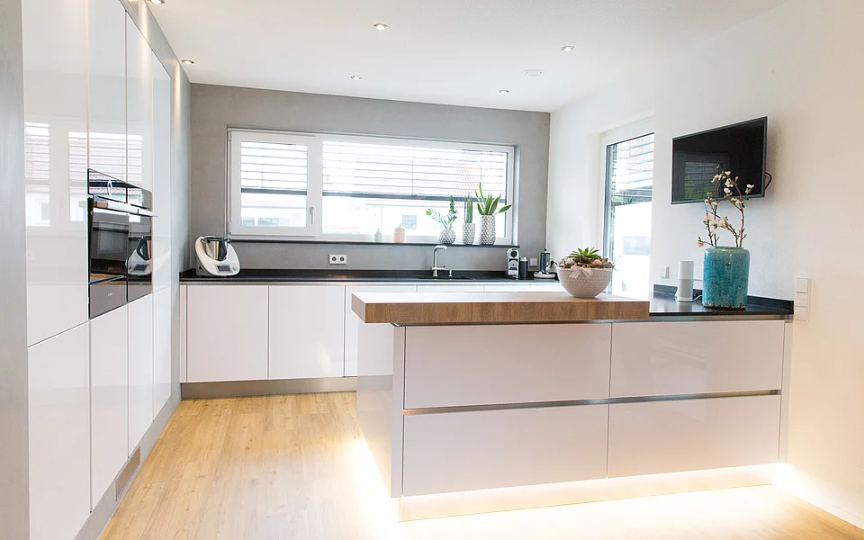 Offene Küche mit großer Fensterfront und moderner Ausstattung, geplant vom Küchenstudio Lorinser