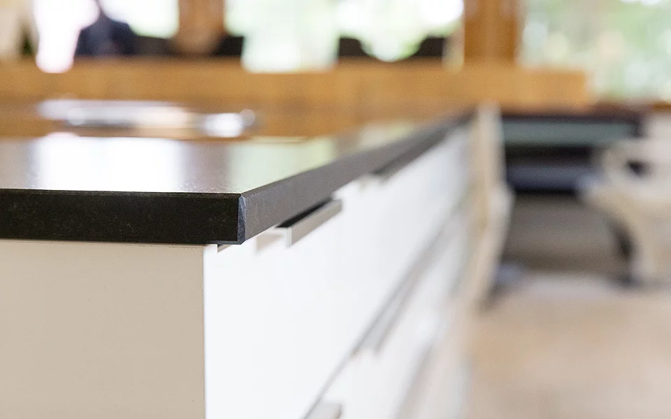 Küche mit großzügiger Arbeitsfläche und Thekenbereich, modern gestaltet, umgesetzt vom Küchenstudio Lorinser