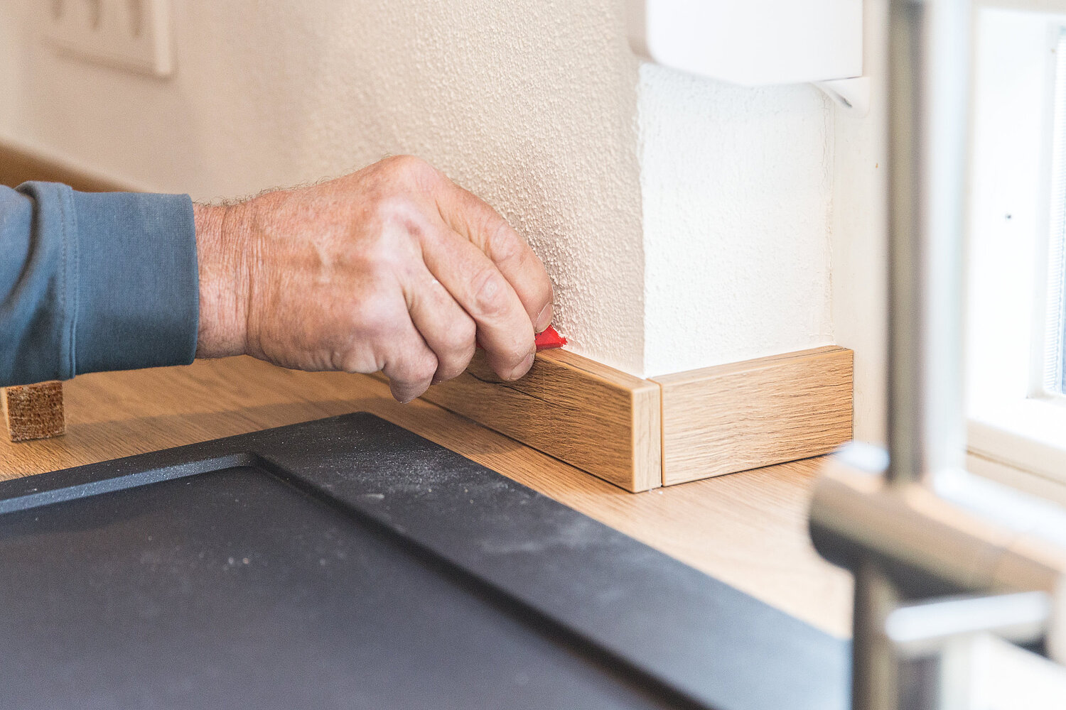 Handwerker passt Küchenarbeitsplatte exakt ein, realisiert vom Küchenstudio Lorinser