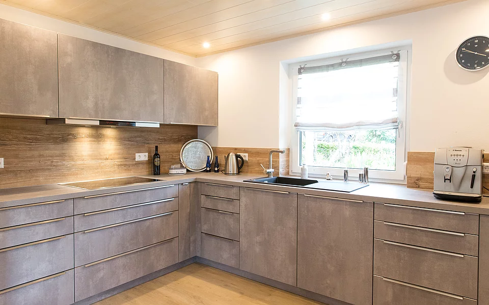 Großzügige Küche mit Kochinsel, hellen Fronten und moderner Ausstattung, umgesetzt vom Küchenstudio Lorinser