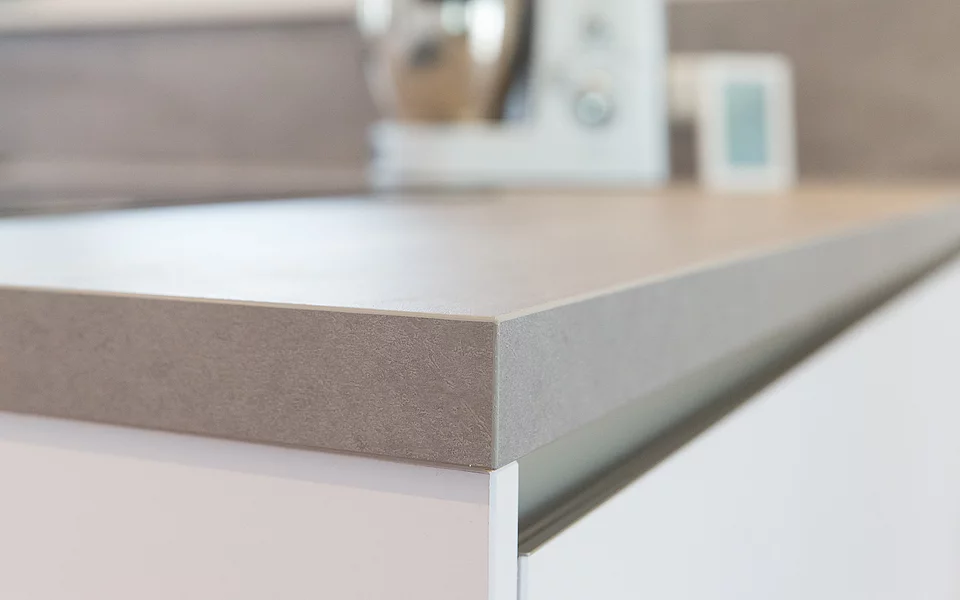 Schlichte Küche mit hellen Fronten und reduziertem Design, umgesetzt vom Küchenstudio Lorinser