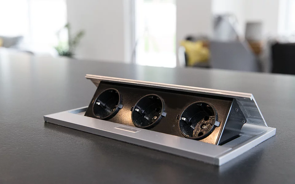 Detailaufnahme eines Kochfelds mit integrierter Stecksdose, umgesetzt vom Küchenstudio Lorinser