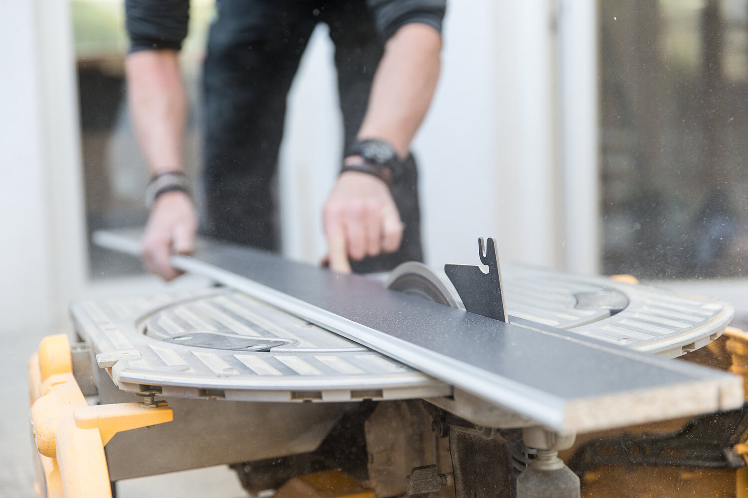 Handwerker bearbeitet Küchenarbeitsplatte mit Säge, Montage durch Küchenstudio Lorinser