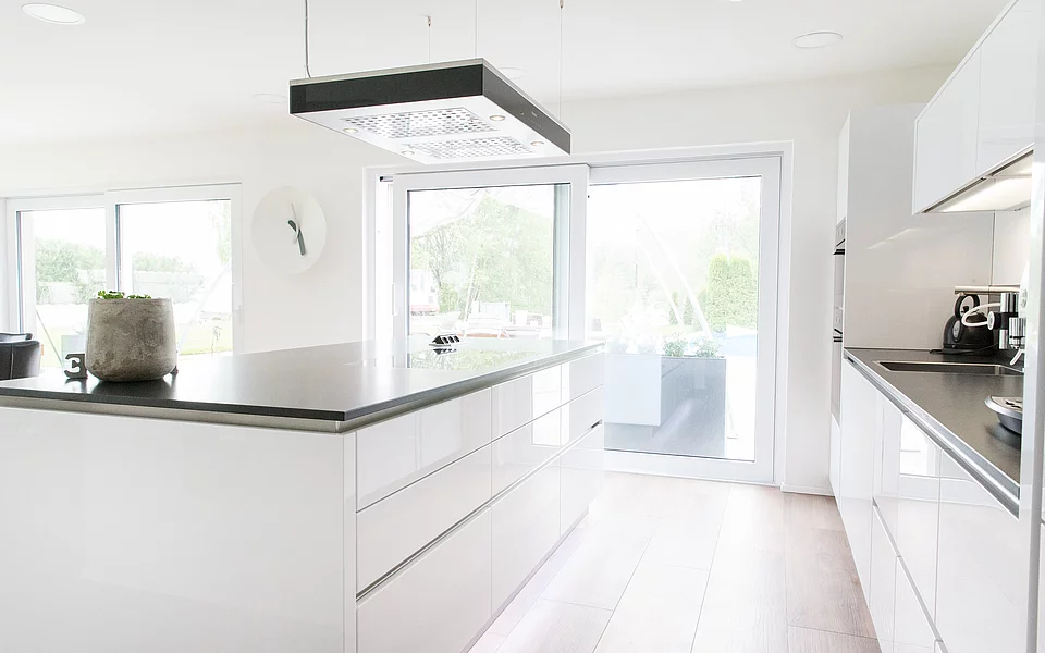 Großzügige Küche mit Kochinsel, hellen Fronten und moderner Ausstattung, geplant vom Küchenstudio Lorinser