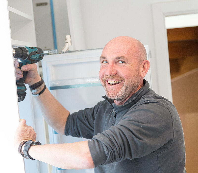 Fachberater erklärt Küchenplanung anhand von Unterlagen, Service vom Küchenstudio Lorinser