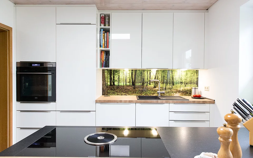 Moderne weiße Hochglanzküche mit Naturelementen