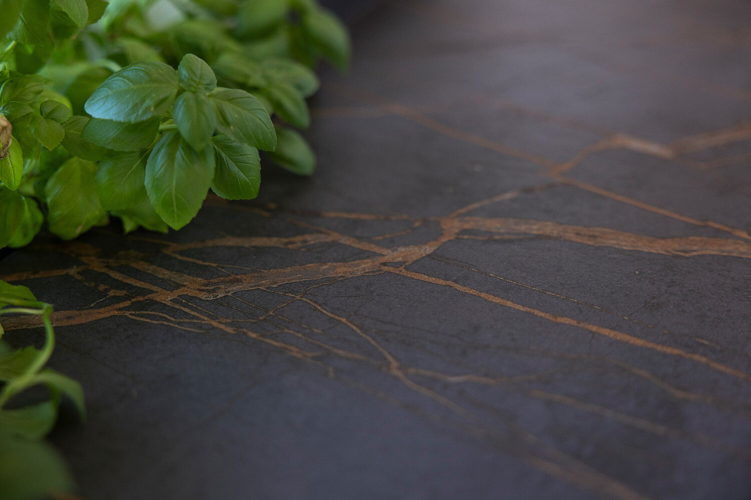 Moderne Steinarbeitsplatt anthrazit mit Highlights in Bronze.