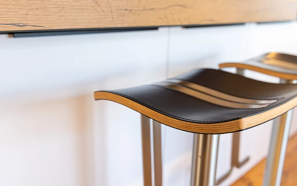 Moderne Küche mit Kücheninsel und Sitzbereich mit Barhockern, realisiert vom Küchenstudio Lorinser