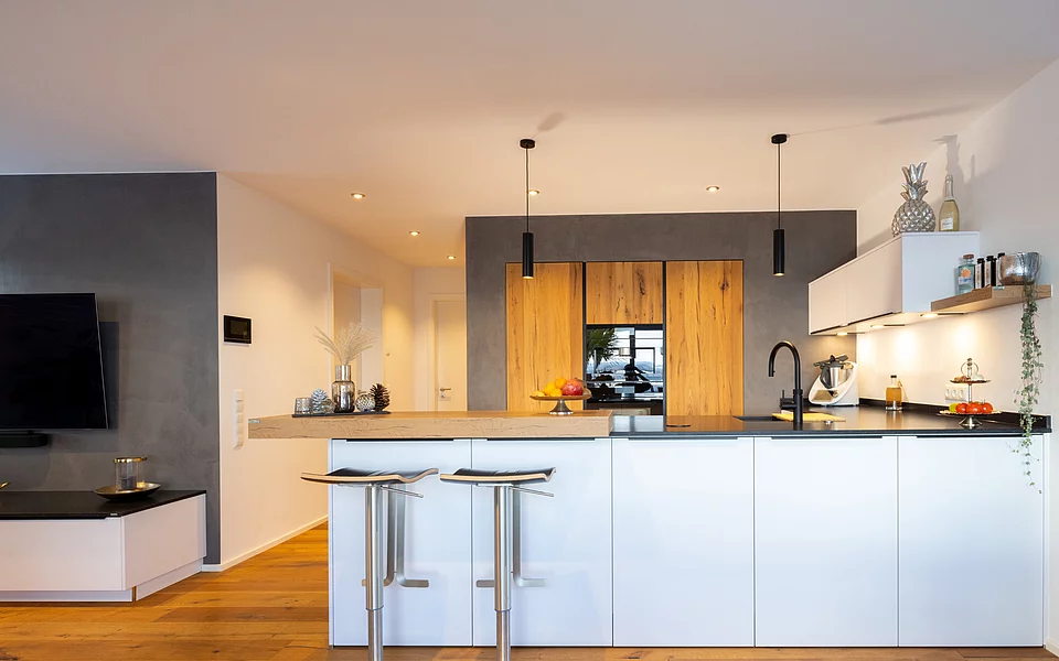 Moderne Küche mit Holzelementen und indirekter Beleuchtung, realisiert vom Küchenstudio Lorinser