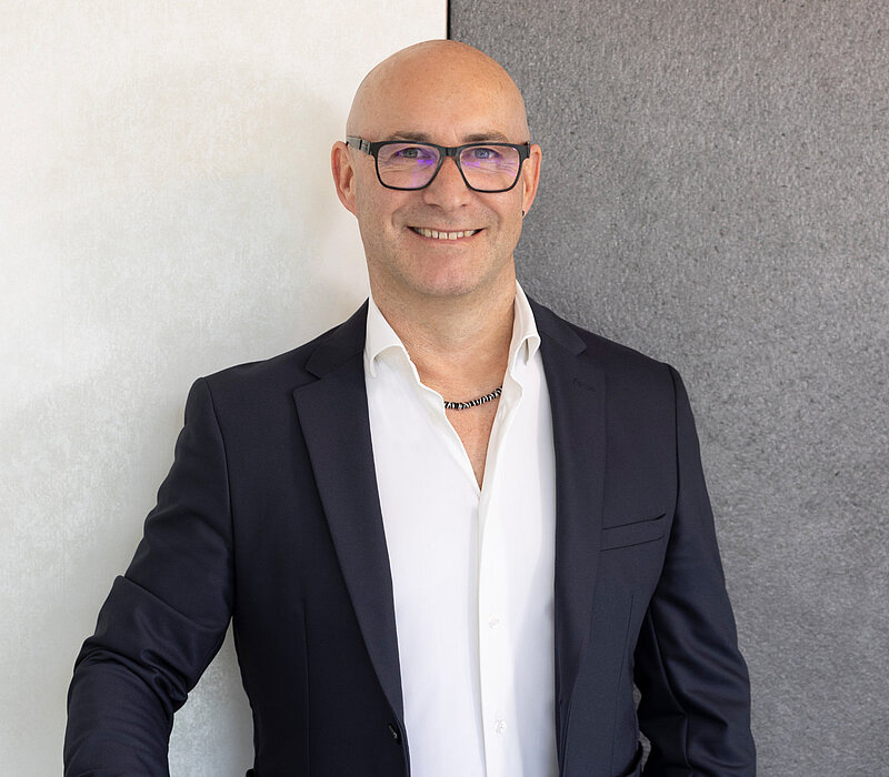 Porträt eines Mannes im Anzug vor heller Wand, Teil des Teams vom Küchenstudio Lorinser