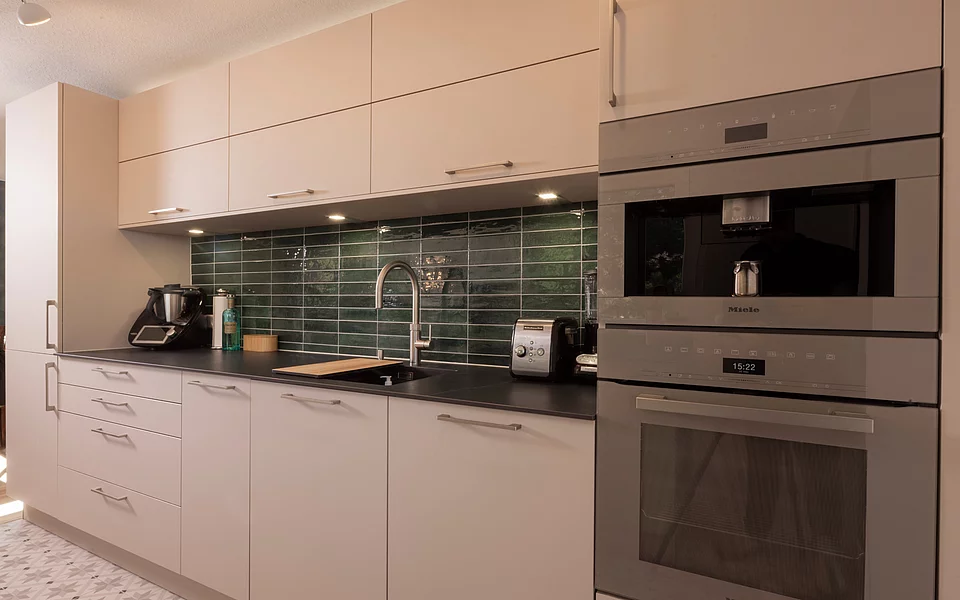 Küche mit integrierten Elektrogeräten, hellen Fronten und funktionalem Design, realisiert vom Küchenstudio Lorinser