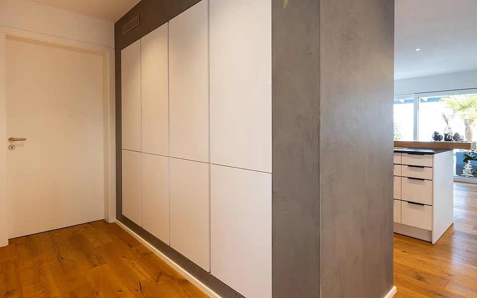 Hochwertige Einbaulösung mit Holzfronten und integrierter Küche, umgesetzt vom Küchenstudio Lorinser