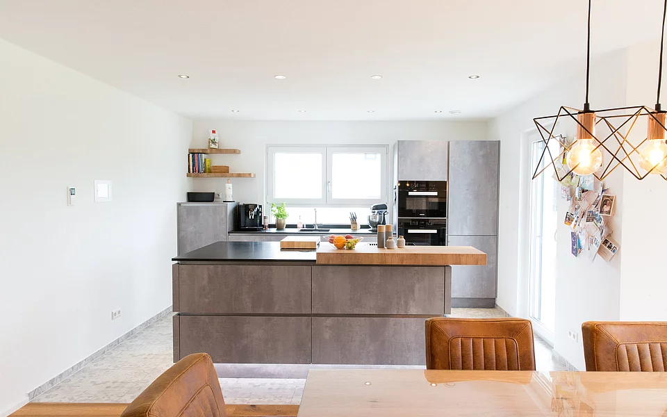 Offene Küche mit integriertem Essbereich und heller, freundlicher Gestaltung, realisiert vom Küchenstudio Lorinser