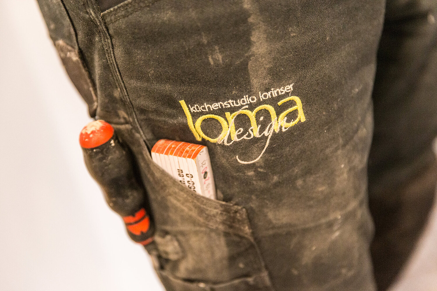 Detailaufnahme von Arbeitskleidung mit Logo des Küchenstudios Lorinser