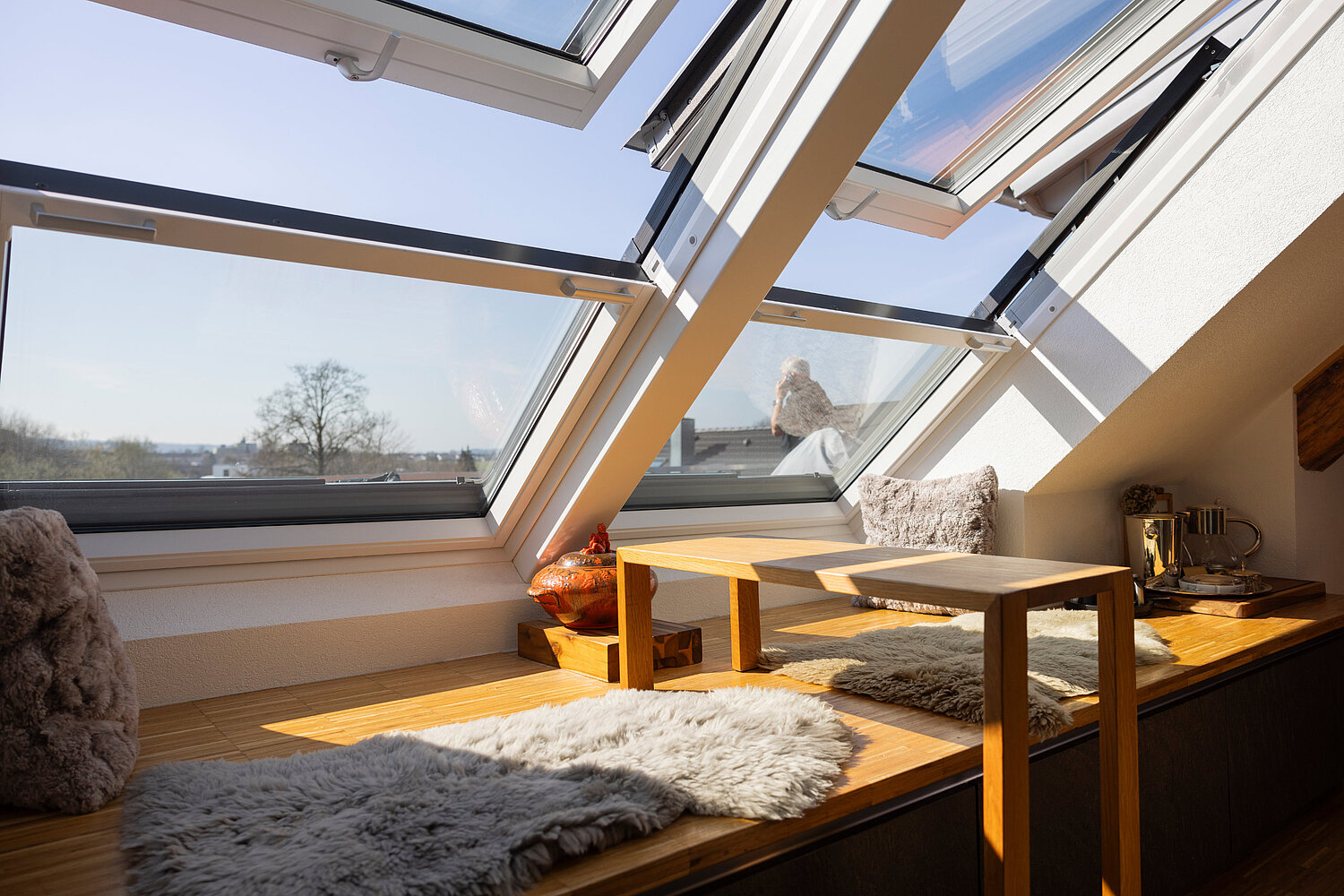 Offene Wohnküche mit Holzelementen, Esstisch und stilvoller Beleuchtung, realisiert vom Küchenstudio Lorinser