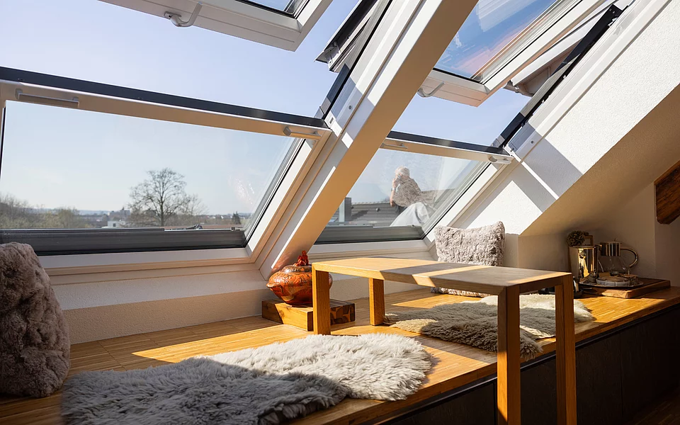 Offene Wohnküche mit Holzelementen, Esstisch und stilvoller Beleuchtung, realisiert vom Küchenstudio Lorinser