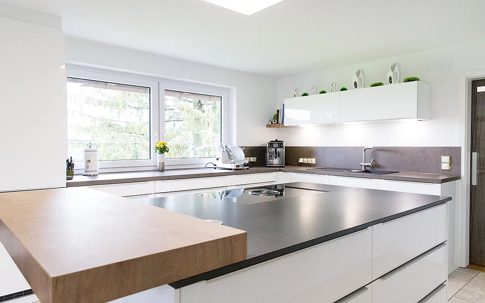 Offene Küche mit großer Kochinsel, hellen Fronten und viel Stauraum, geplant vom Küchenstudio Lorinser