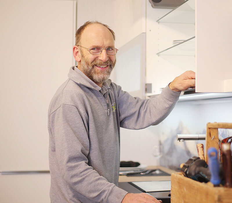 Handwerker montiert Küchenschrank und arbeitet an Einbauküche, umgesetzt vom Küchenstudio Lorinser